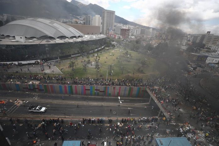 Manifestantes se retiran al comienzo del toque de queda durante el décimo día de protestas contra el gobierno este sábado, en Quito. | Foto: José Jácome